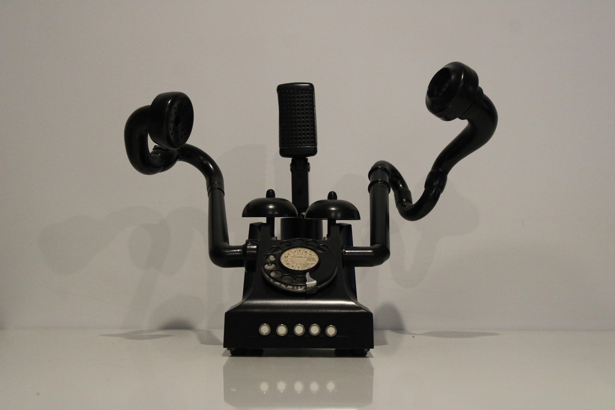 A sculpture made from repurposed telephone components, showcasing an innovative communication device.