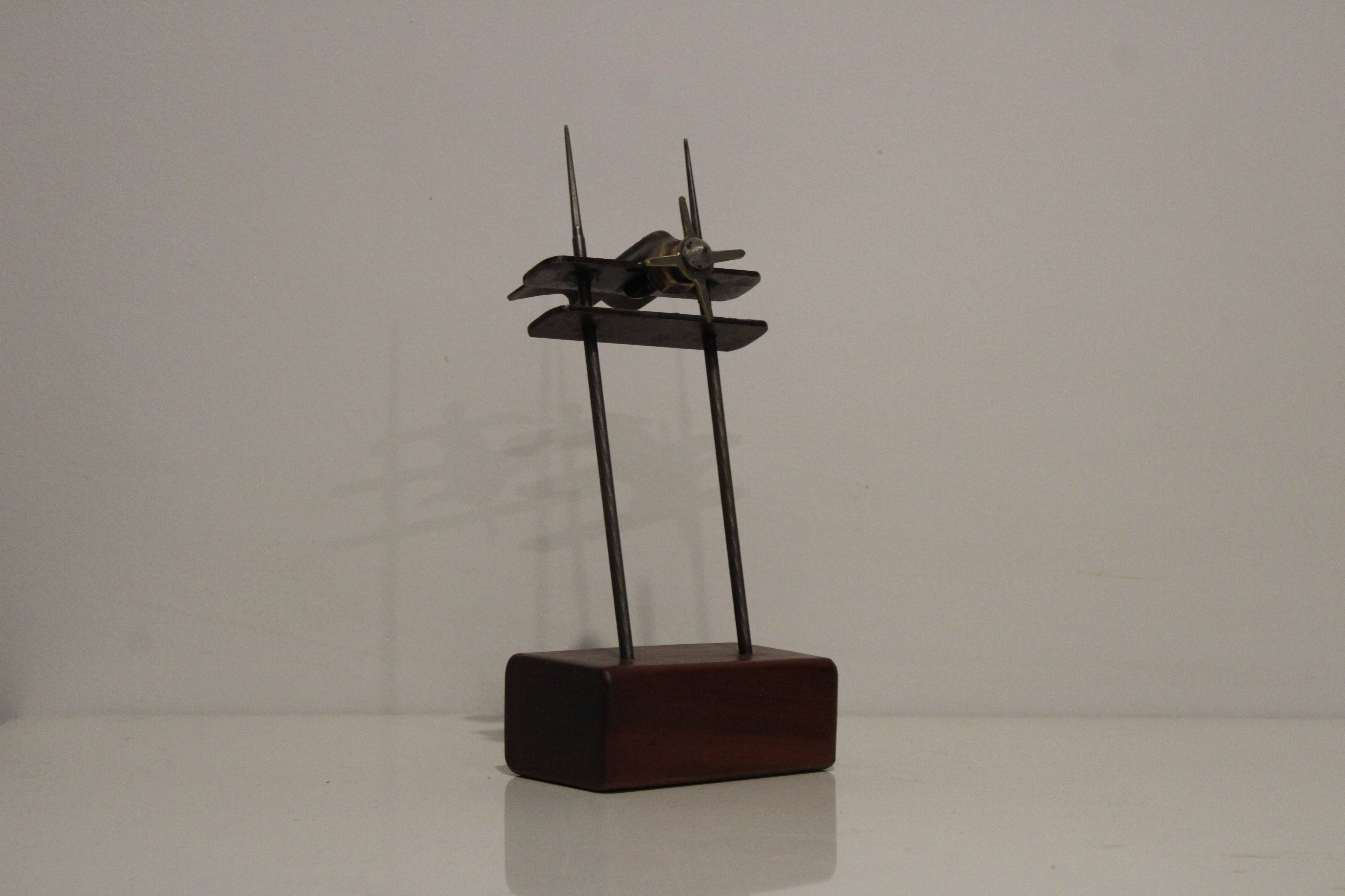 A sculpture of a plane made from timber, steel and brass