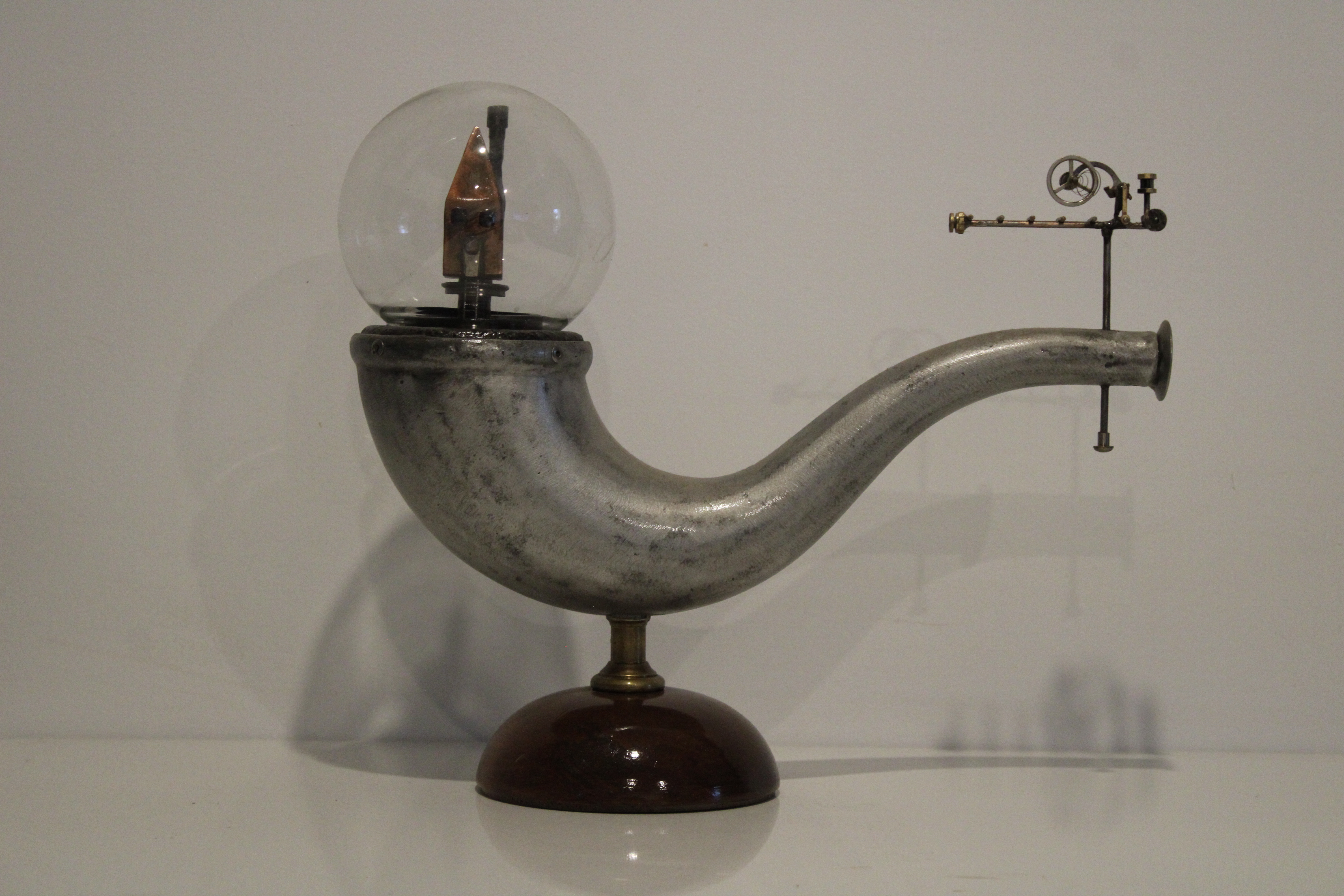 An abstract sculpture with a pipe-like shape depicting a house in a glass bubble