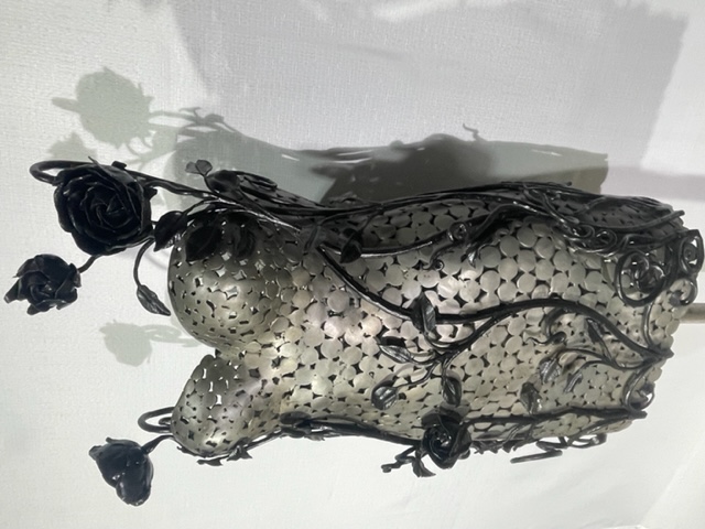 A steel and forged wrought iron dress sculpture with black roses