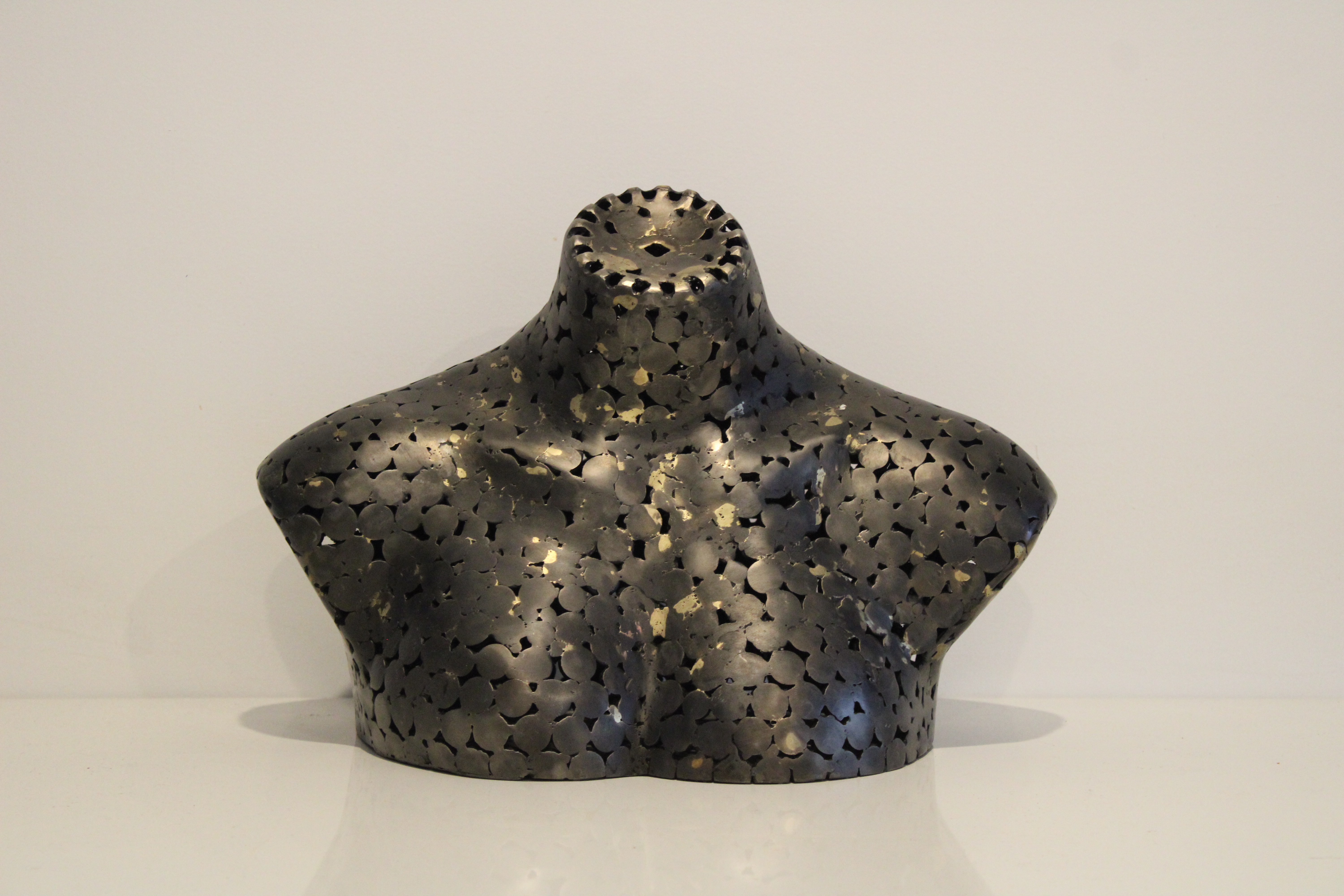 A mild steel sculpture of a woman's bust with brass inlay